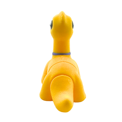 Monty the Brachiosaurus Flexling toy in yellow with purple fancy bow tie, limited edition collectible dinosaur figure