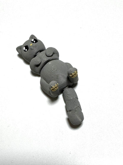 Mochi the Cat Flexling toy in black, lying on back with paws up in relaxed belly-up pose