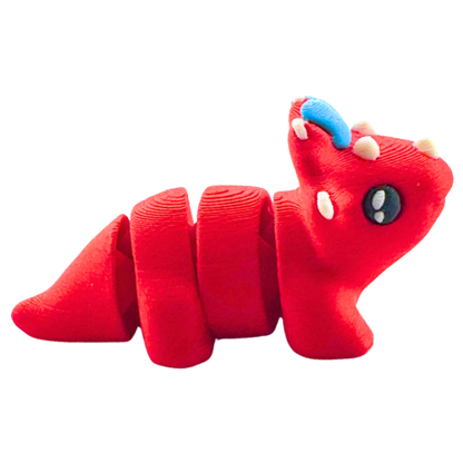 Red triceratops toy with large blue bow on frill, Fancy Edition collectible figure