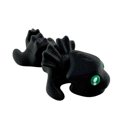 Ember the Dragon Flexling toy in dark gray with black eyes, poseable dragon figure from limited Original Crew edition