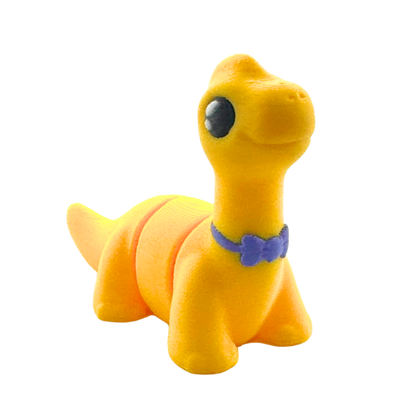 Monty the Brachiosaurus Flexling toy in yellow with purple fancy bow tie, limited edition collectible dinosaur figure