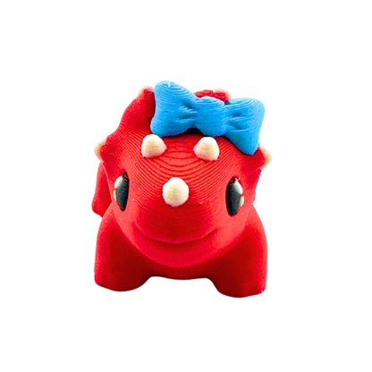 Red triceratops toy with large blue bow on frill, Fancy Edition collectible figure