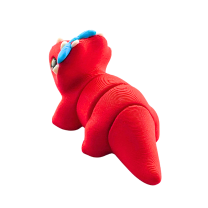 Red triceratops toy with large blue bow on frill, Fancy Edition collectible figure